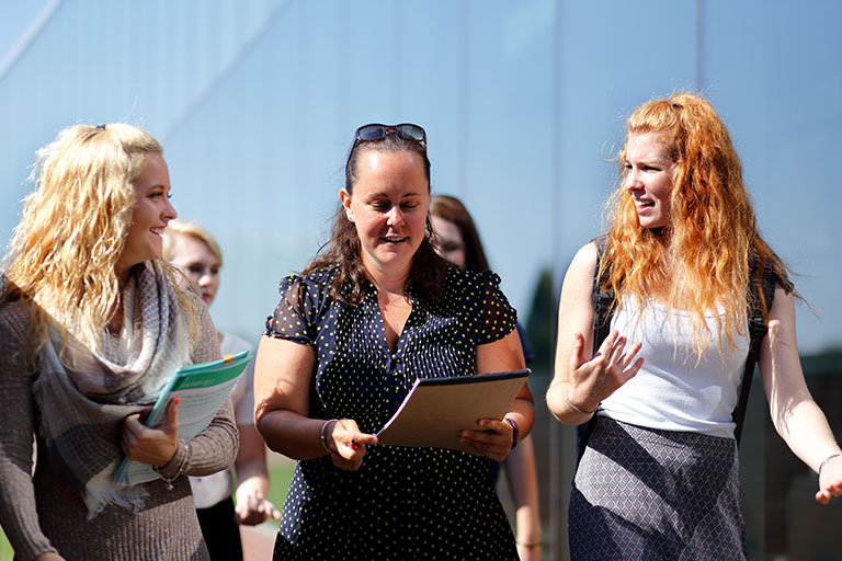 Photo of students walking with professor Anna Carmon.