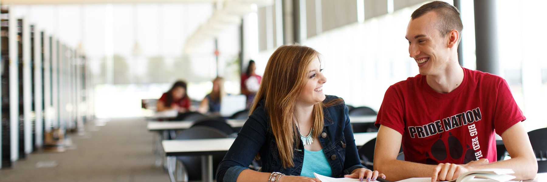 Photo of students talking in the library.